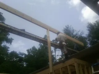 Carpenter setting a ridge beam over a new addition frame — Ice Dam Removal by Roofing Brothers in Register