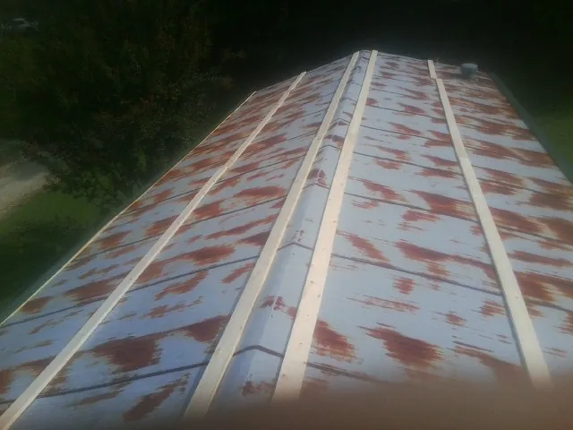 Rusted metal roof panels with new wood purlins before replacement — Storm Damage Roof Repair in Register by Roofing Brothers