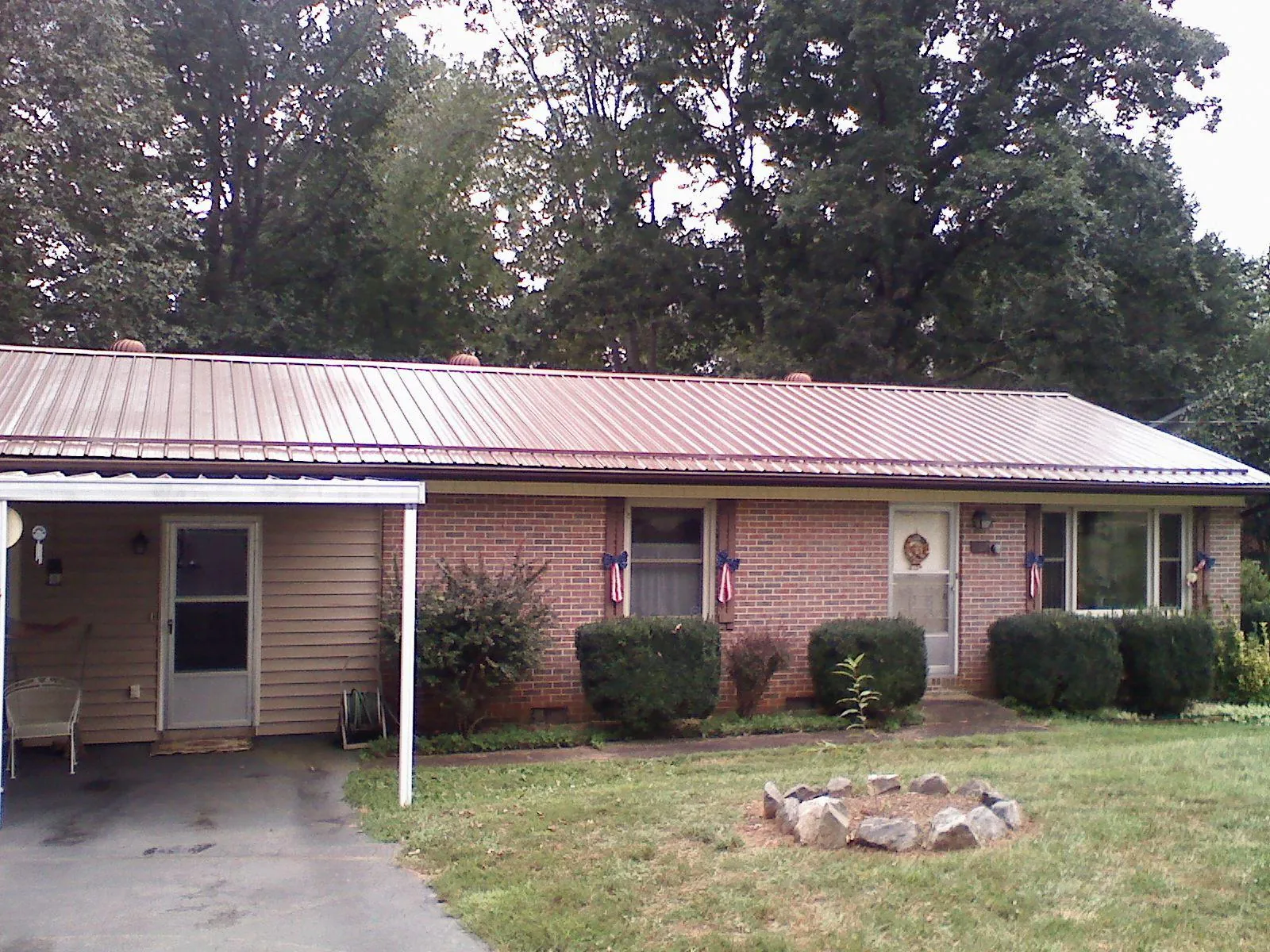 Bronze metal roof and carport on a brick ranch home — Roof Repair work by our crew in Register